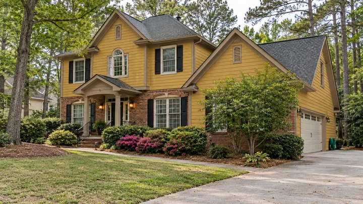 AI color concept: the same home with dated yellow siding and brown trim